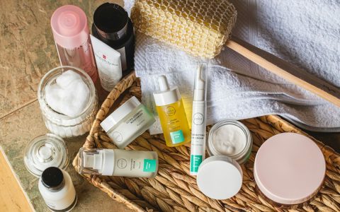 Produk perawatan kulit tersusun di rak kamar mandi