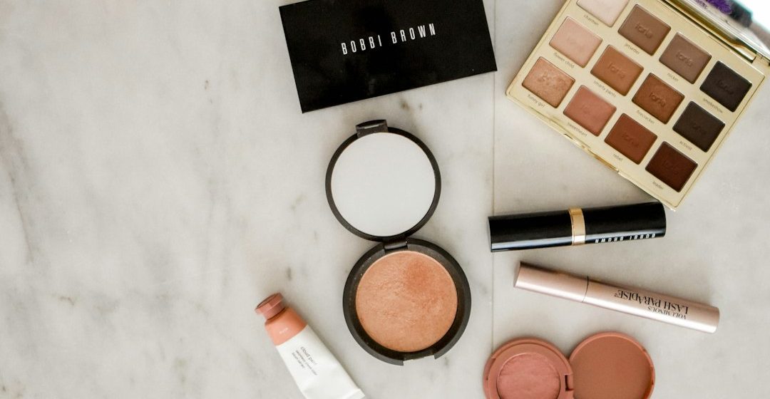 Aneka produk makeup di atas permukaan abu-abu