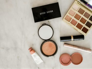 Aneka produk makeup di atas permukaan abu-abu