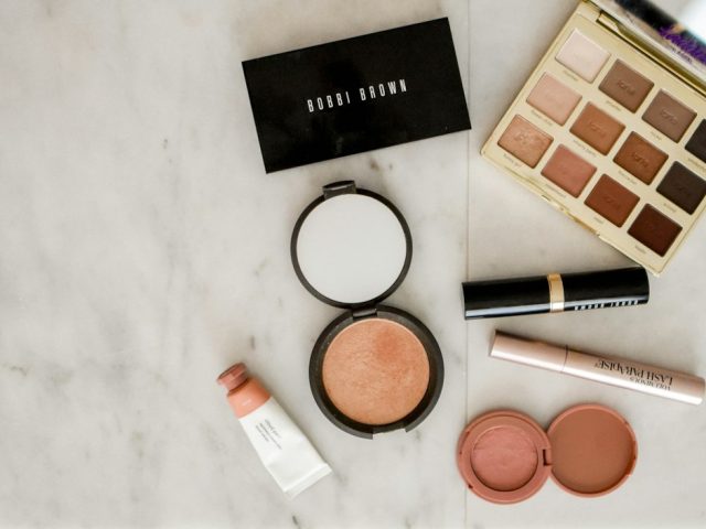 Aneka produk makeup di atas permukaan abu-abu